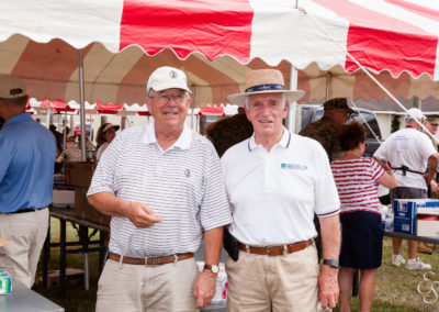 two men wearing hats under a tent