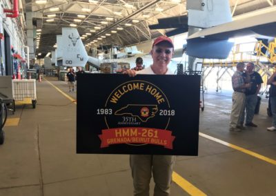 Man holding HMM-261 welcome home sign